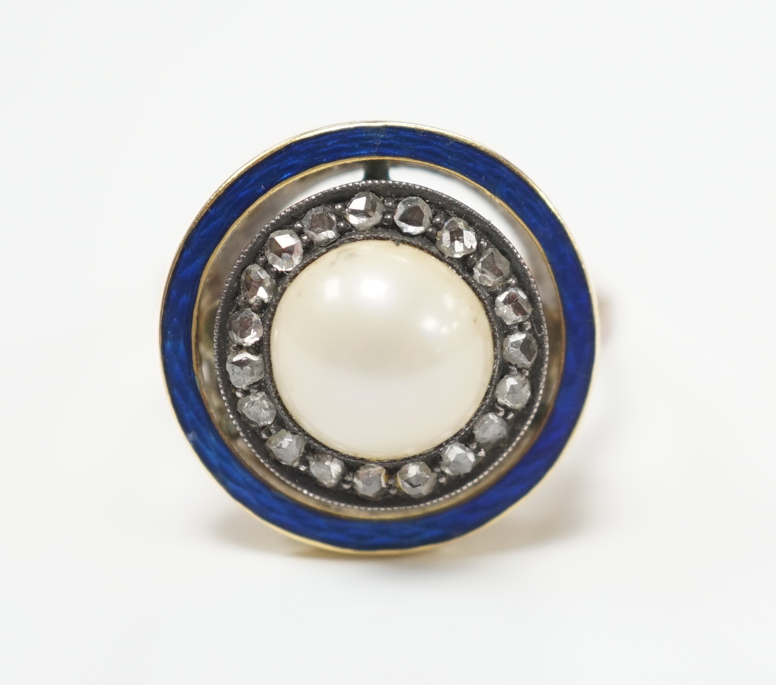 An early to mid 20th century yellow metal, split pearl, rose cut diamond chip and blue enamel set target ring, size H, ross weight 4.6 grams.